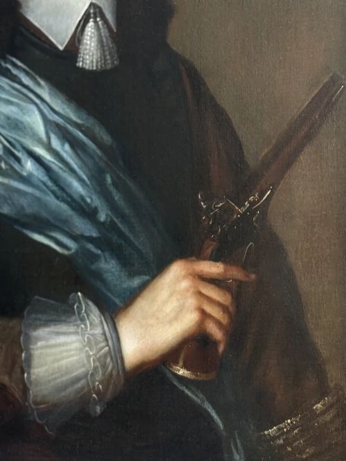 fig 4. A half-length 17th-century portrait painting of a gentleman holding a pistol, wearing a blue sash, framed in a carved giltwood frame.