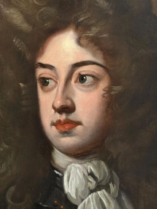 fig 1. An oval Baroque oil portrait depicting a nobleman in plate armour with a white lace cravat and full wig, housed in a carved gilded frame.