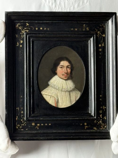 fig 3. An oval 17th-century oil portrait miniature on copper depicting a gentleman with a mustache and lace collar in a black ebonised frame with gilt detail.