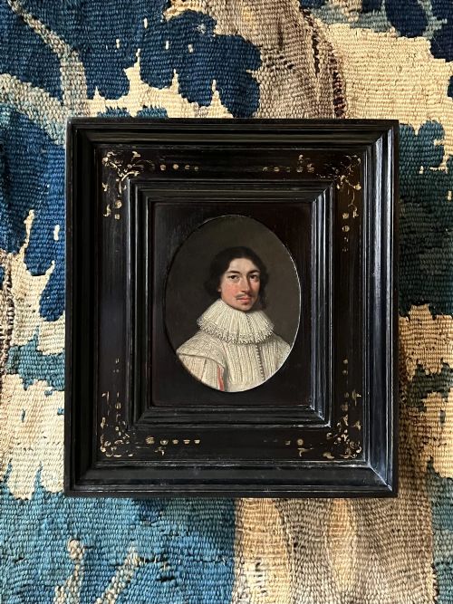 fig 4. An oval 17th-century oil portrait miniature on copper depicting a gentleman with a mustache and lace collar in a black ebonised frame with gilt detail.