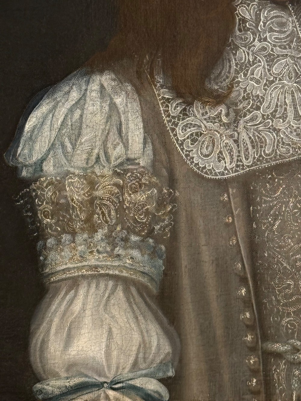 A seventeenth-century oil portrait depicting a young gentleman wearing an intricate lace collar and embroidered clothing in a carved silvered frame. View IV