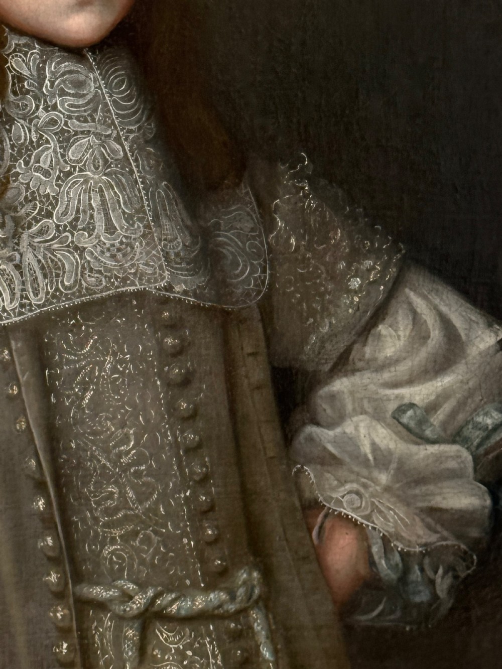 A seventeenth-century oil portrait depicting a young gentleman wearing an intricate lace collar and embroidered clothing in a carved silvered frame. View V