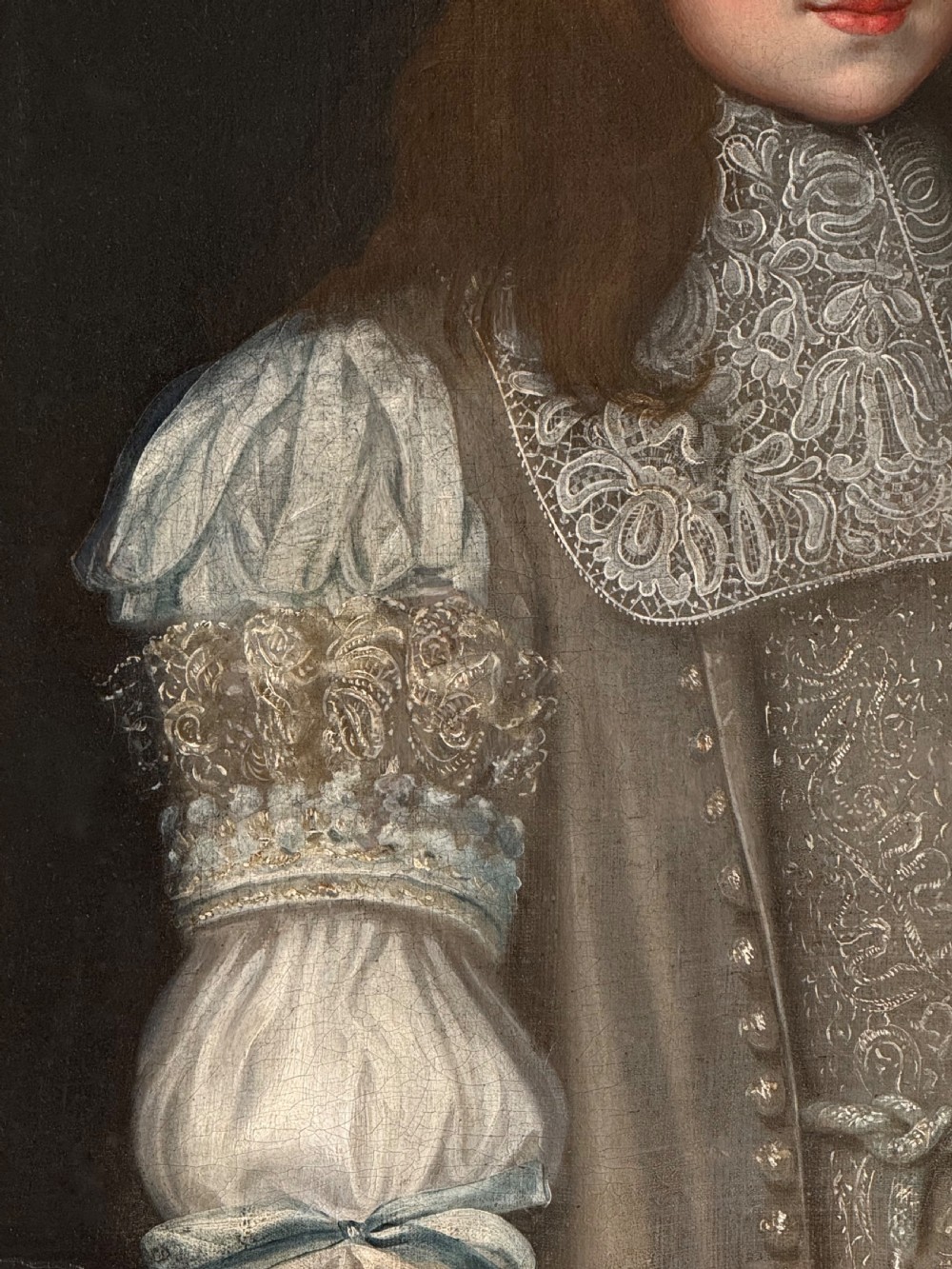 A seventeenth-century oil portrait depicting a young gentleman wearing an intricate lace collar and embroidered clothing in a carved silvered frame. View VIII