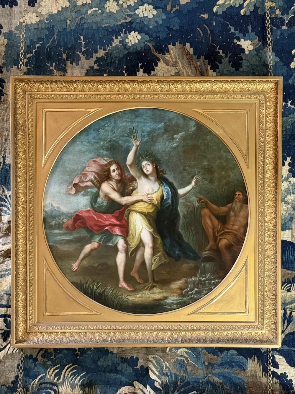 An 18th-century circular classical oil painting set in a square gilded frame depicting the mythological narrative of Apollo and Daphne.