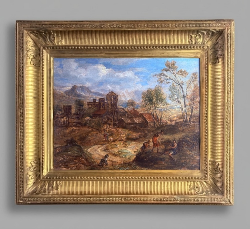 An oil painting on wooden panel depicting an idyllic pastoral landscape with classical figures, stone buildings, and distant mountains, set within a carved gilded frame.