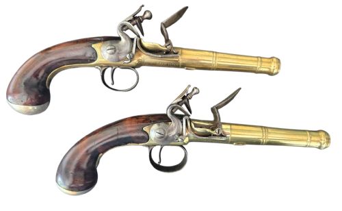 fig 3. A pair of 18th-century English flintlock turn-off pistols featuring brass cannon barrels, steel lock mechanisms, and smooth walnut stocks.