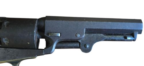 fig 2. An antique Colt Model 1849 pocket revolver with an octagonal dark steel barrel, smooth walnut grip, and brass trigger guard.
