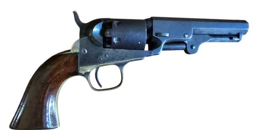 fig 3. An antique Colt Model 1849 pocket revolver with an octagonal dark steel barrel, smooth walnut grip, and brass trigger guard.