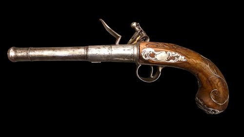 QUEEN ANNE SILVERMOUNTED 18 BORE FLINTLOCK HOLSTER PISTOL BY R WILLOUGHBY BIRMINGHAMEARLY 18THCENTURY ENGLISH FLINTLOCK PISTOL SILVERWIRE INLAID WALNUT GRIP SILVER GROTESQUE BUTT CAP WITH SILVER VACANT CARTOUCHES TO THE TOP AND THE SIDE OF THE STOCK CIRCA 1730 - ADDITIONAL PHOTO 1