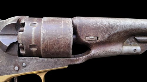 fig 1. Side profile of a patinated steel Colt Model 1860 Army percussion revolver featuring a walnut handle grip and brass trigger guard.
