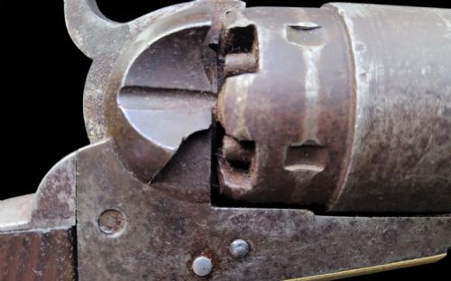 fig 2. Side profile of a patinated steel Colt Model 1860 Army percussion revolver featuring a walnut handle grip and brass trigger guard.