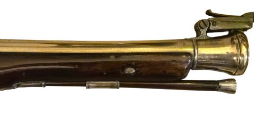 fig 2. Late eighteenth-century British flintlock blunderbuss featuring a flared brass barrel, dark polished walnut stock, steel flintlock action, top-mounted sprung bayonet, and a separate wooden ramrod.
