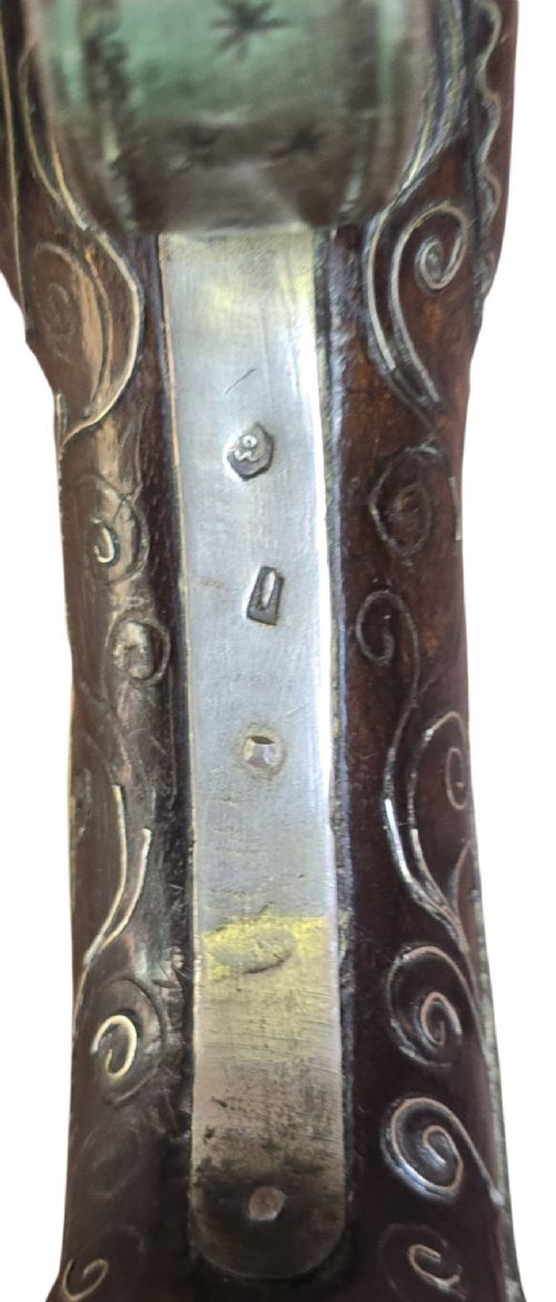 An early 19th-century Ottoman Balkan flintlock holster pistol featuring a dark wood stock inlaid with silver wire scrollwork and a cast brass pommel. View X