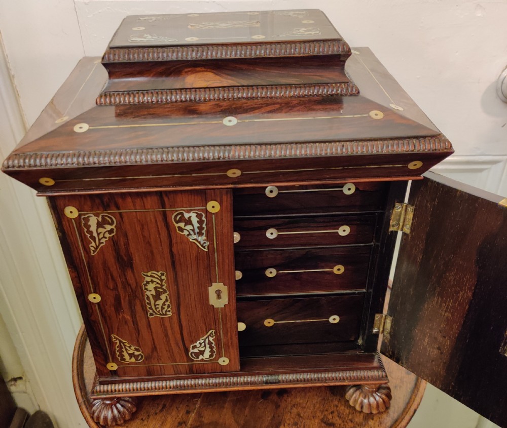 A Georgian dark rosewood tabletop cabinet featuring mother of pearl inlay, a sarcophagus-shaped top, side brass handles, and carved feet. View IV