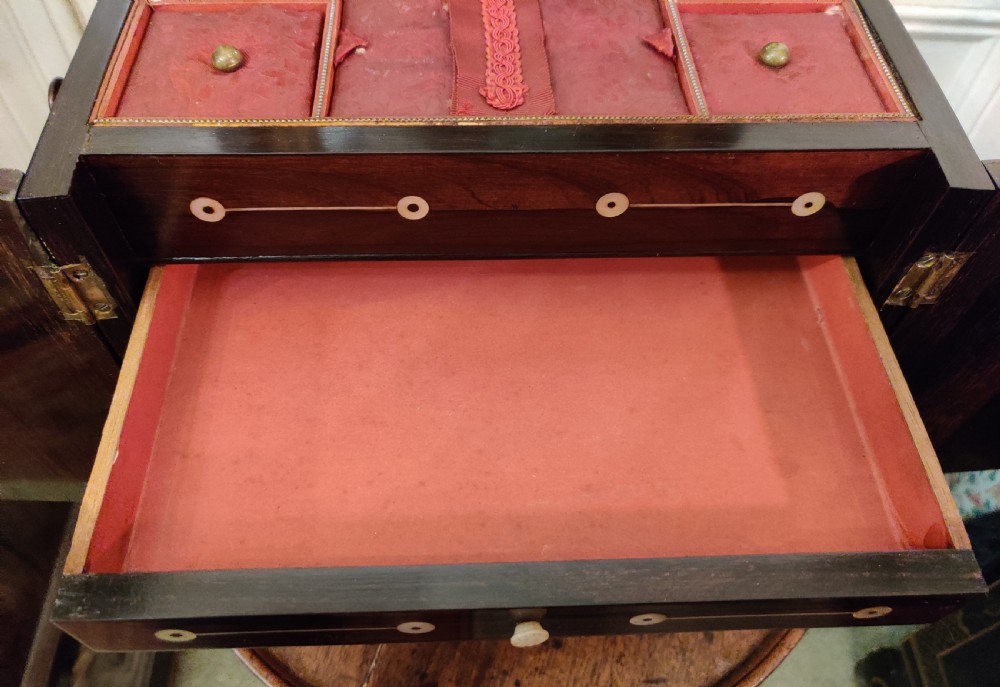 A Georgian dark rosewood tabletop cabinet featuring mother of pearl inlay, a sarcophagus-shaped top, side brass handles, and carved feet. View XVI