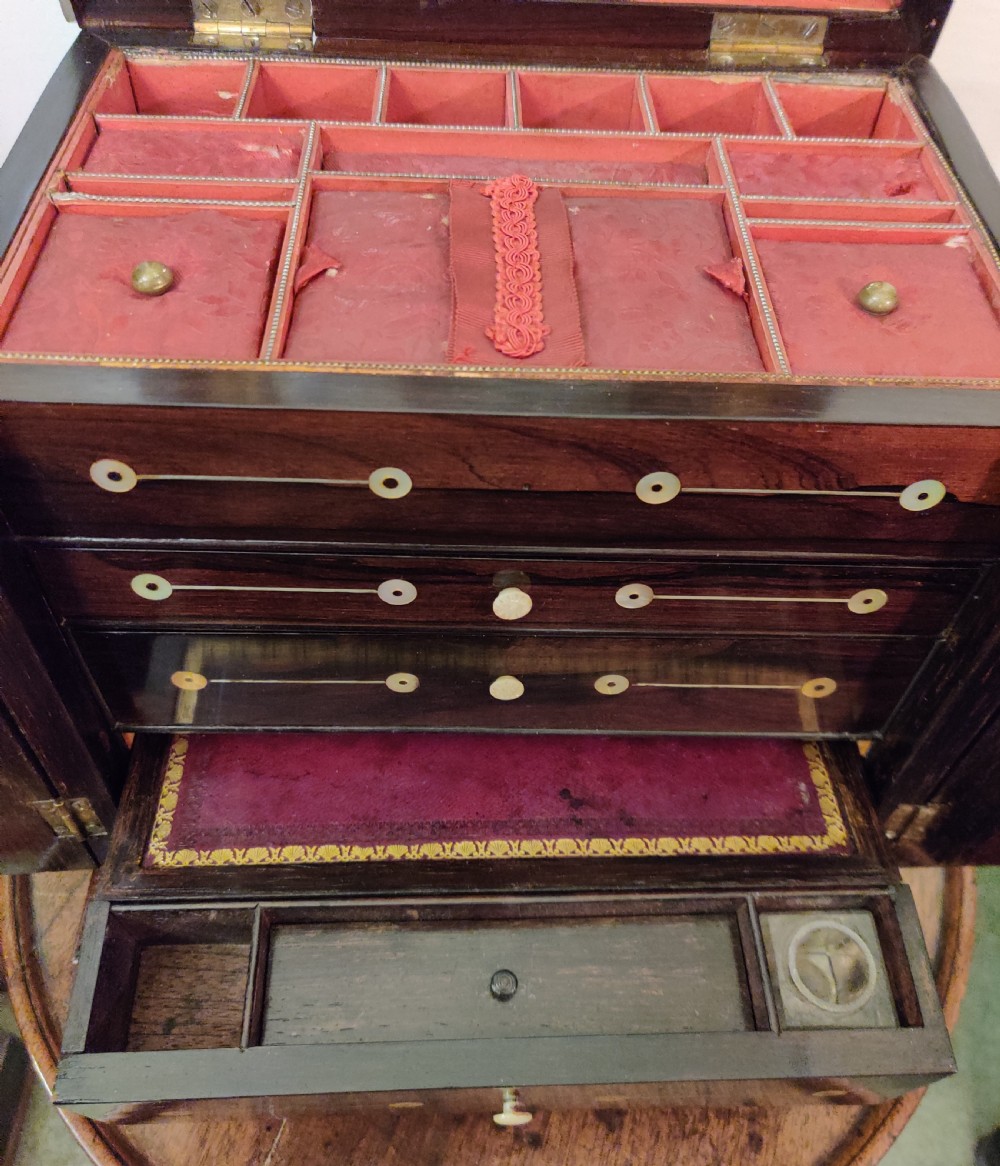 A Georgian dark rosewood tabletop cabinet featuring mother of pearl inlay, a sarcophagus-shaped top, side brass handles, and carved feet. View XXII