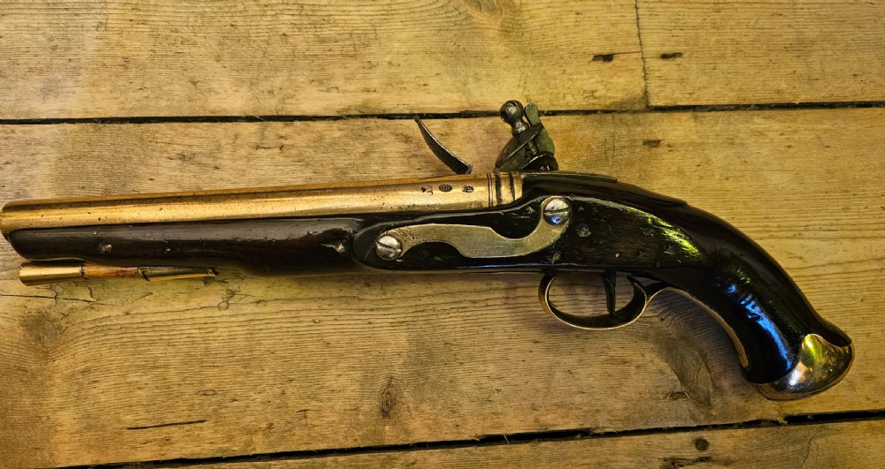 A late 18th-century Light Dragoon service flintlock pistol featuring a brass barrel, dark walnut stock, and steel ignition lock mechanism. View V