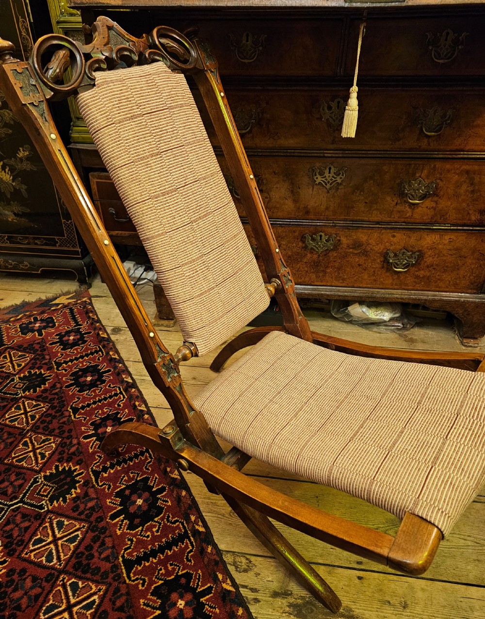 A nineteenth-century carved walnut folding campaign chair with woven fabric upholstery, turned finials, and bone inlay detail. View VI