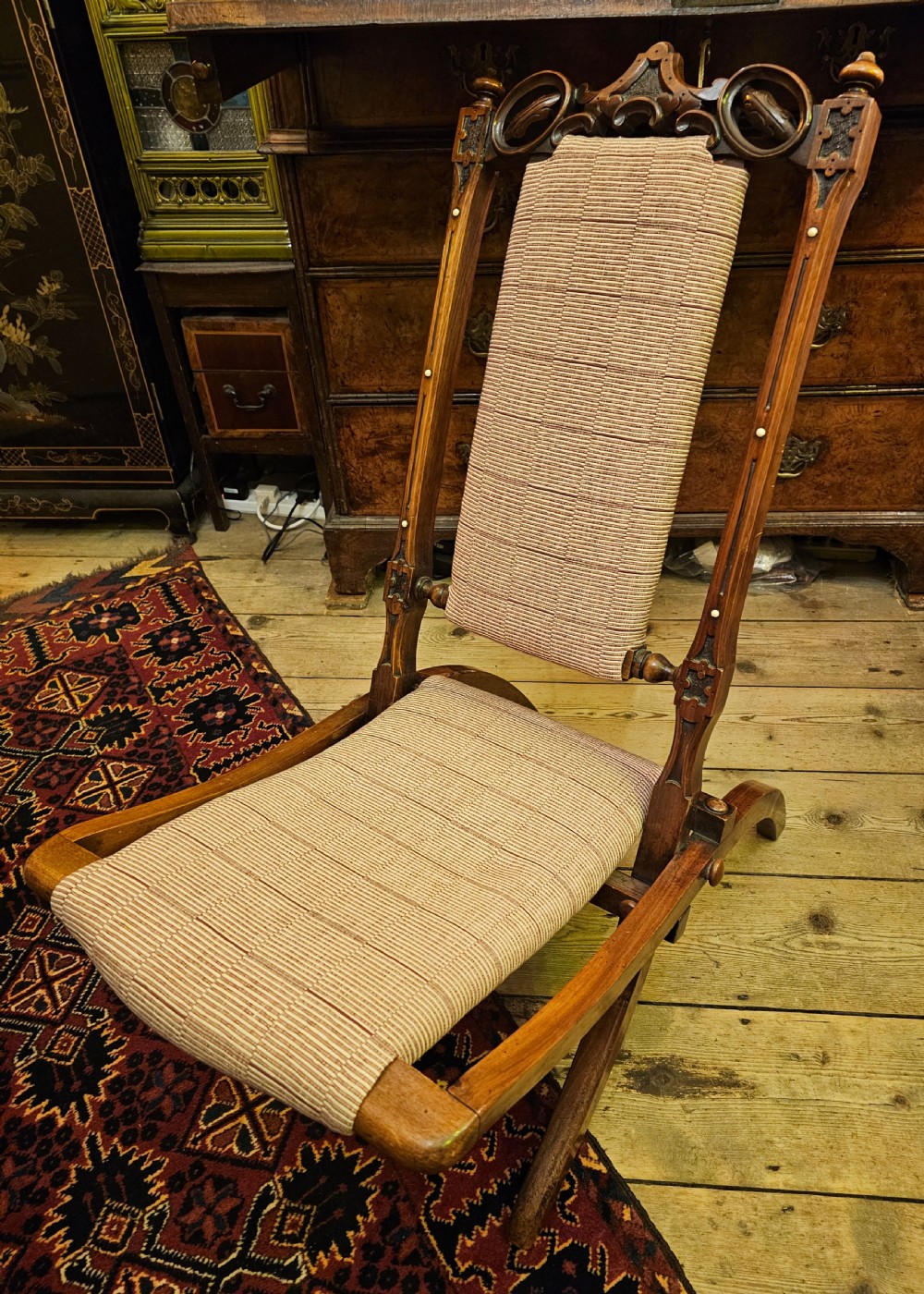 A nineteenth-century carved walnut folding campaign chair with woven fabric upholstery, turned finials, and bone inlay detail. View VII