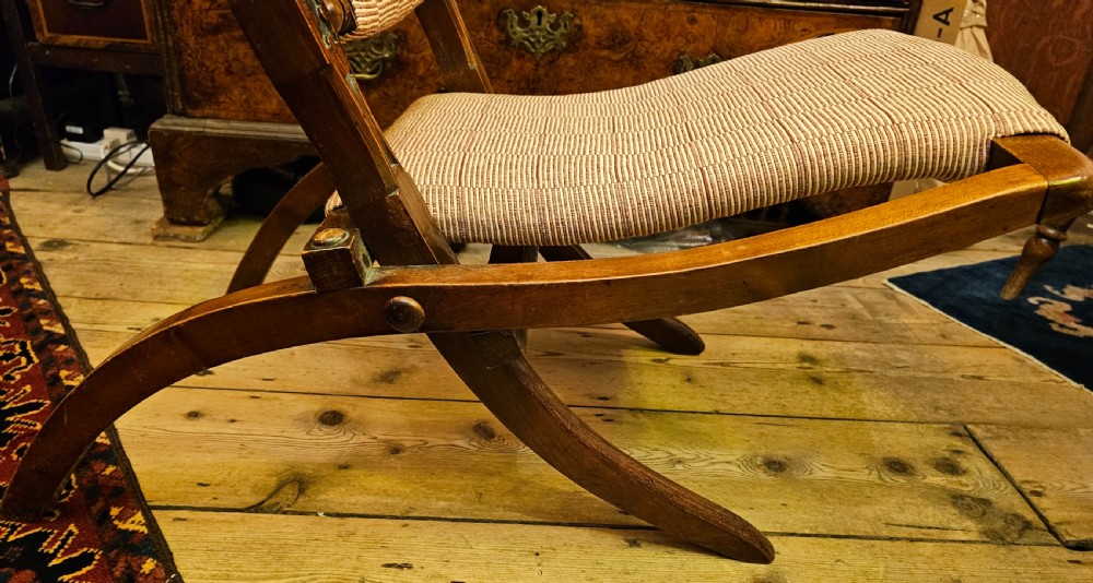 A nineteenth-century carved walnut folding campaign chair with woven fabric upholstery, turned finials, and bone inlay detail. View VIII