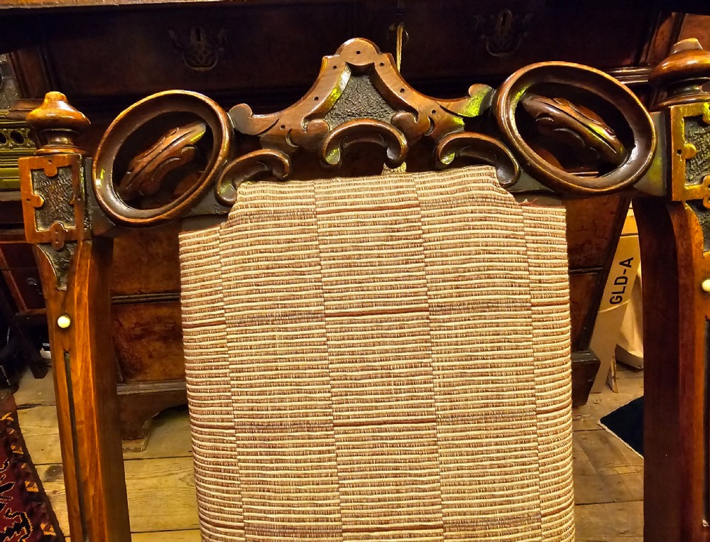 A nineteenth-century carved walnut folding campaign chair with woven fabric upholstery, turned finials, and bone inlay detail. View XII