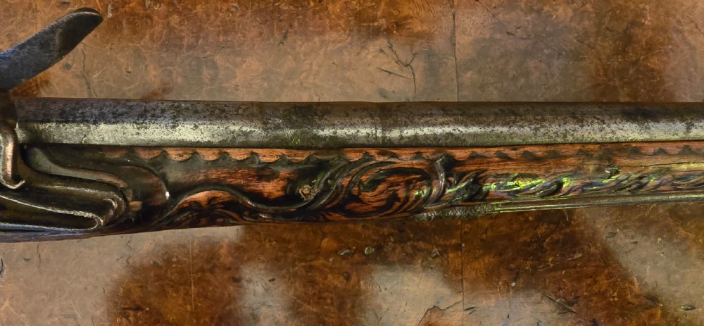 An 18th-century Balkan Ottoman flintlock holster pistol featuring a carved wooden stock, steel barrel, and a bulbous pommel. View IV