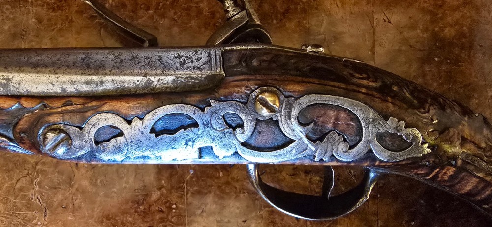An 18th-century Balkan Ottoman flintlock holster pistol featuring a carved wooden stock, steel barrel, and a bulbous pommel. View IX