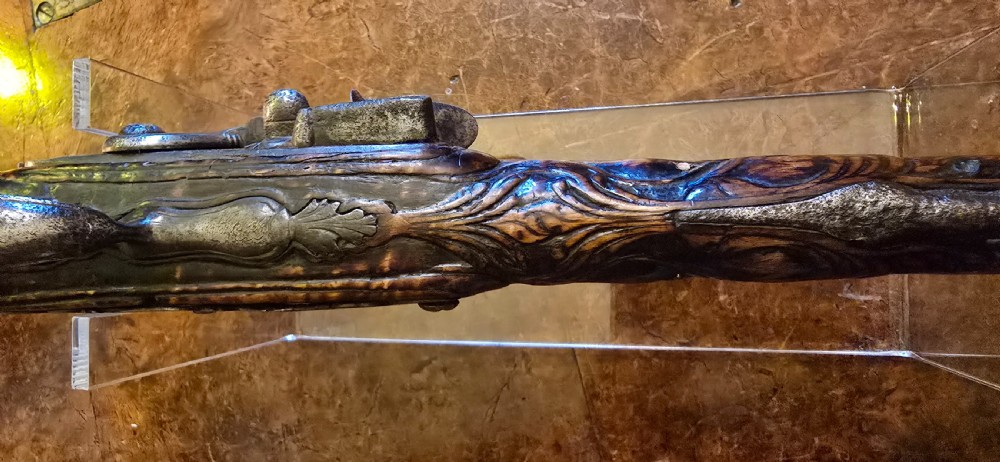 An 18th-century Balkan Ottoman flintlock holster pistol featuring a carved wooden stock, steel barrel, and a bulbous pommel. View XXX