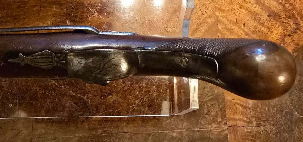 An 1840s percussion belt pistol featuring an engraved steel lockplate, octagonal barrel, and a carved walnut stock with a cross-hatched grip. View XII