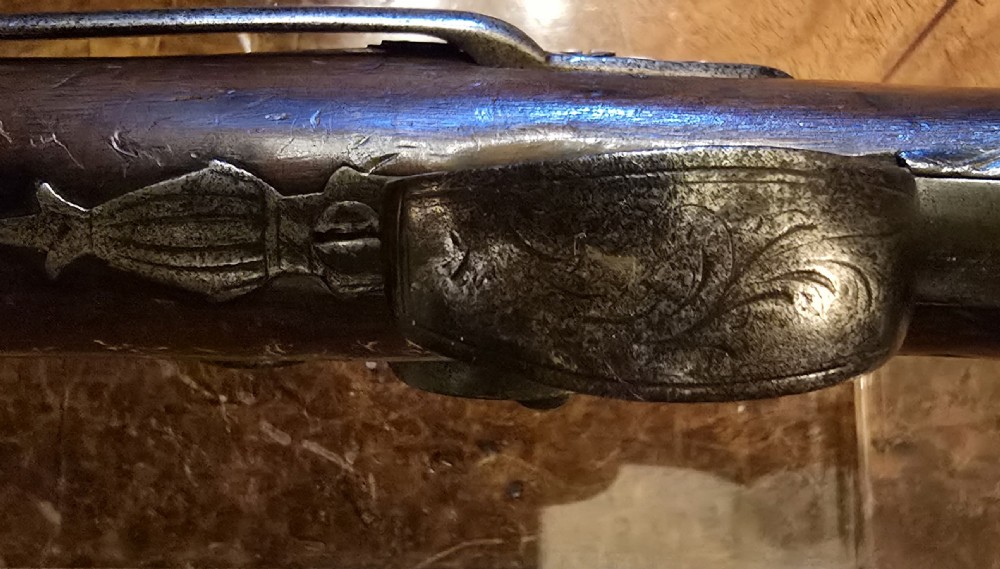 An 1840s percussion belt pistol featuring an engraved steel lockplate, octagonal barrel, and a carved walnut stock with a cross-hatched grip. View XIII