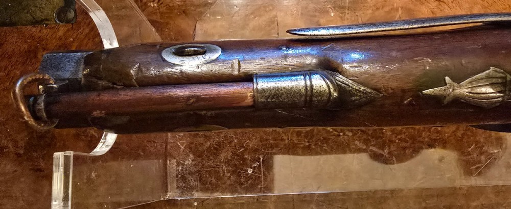 An 1840s percussion belt pistol featuring an engraved steel lockplate, octagonal barrel, and a carved walnut stock with a cross-hatched grip. View XIV