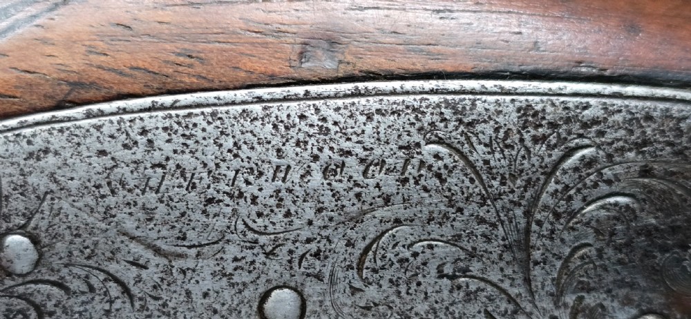 An 1840s percussion belt pistol featuring an engraved steel lockplate, octagonal barrel, and a carved walnut stock with a cross-hatched grip. View XVII
