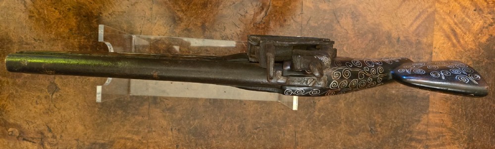 An antique dark wood snaphaunce flintlock pistol featuring intricate silver wire scrollwork inlay along the stock and a steel ignition mechanism. View XVII