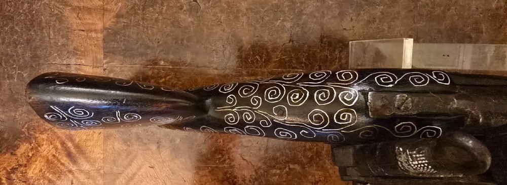 An antique dark wood snaphaunce flintlock pistol featuring intricate silver wire scrollwork inlay along the stock and a steel ignition mechanism. View XXII