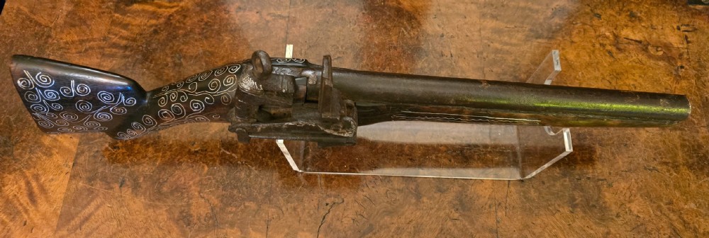 An antique dark wood snaphaunce flintlock pistol featuring intricate silver wire scrollwork inlay along the stock and a steel ignition mechanism. View XXIII