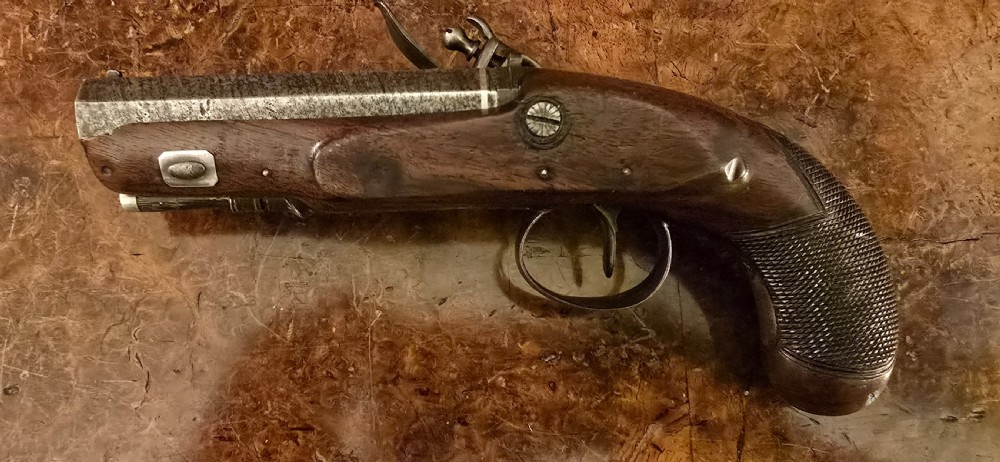 A Georgian British flintlock pocket pistol with a short octagonal barrel. Silver band & cartouche (not hallmarked), by 
Sutherland of London.  View XX