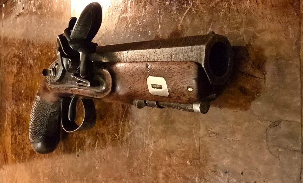 A Georgian British flintlock pocket pistol with a short octagonal barrel. Silver band & cartouche (not hallmarked), by 
Sutherland of London.  View XXI