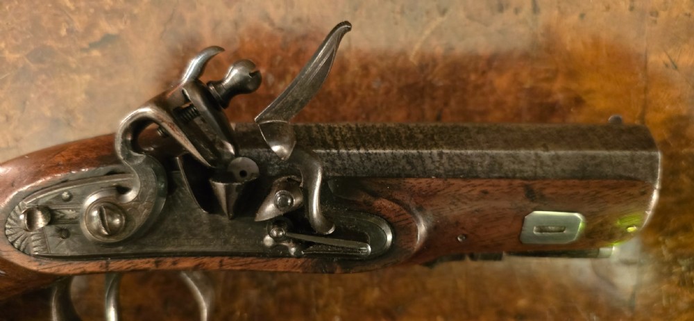A Georgian British flintlock pocket pistol with a short octagonal barrel. Silver band & cartouche (not hallmarked), by 
Sutherland of London.  View XXII