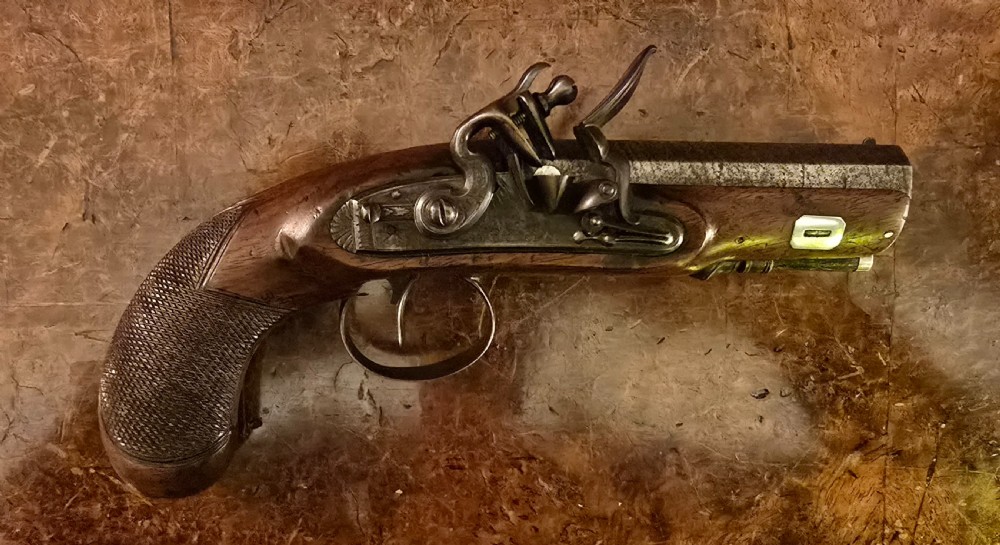A Georgian British flintlock pocket pistol with a short octagonal barrel. Silver band & cartouche (not hallmarked), by 
Sutherland of London.  View XXIII