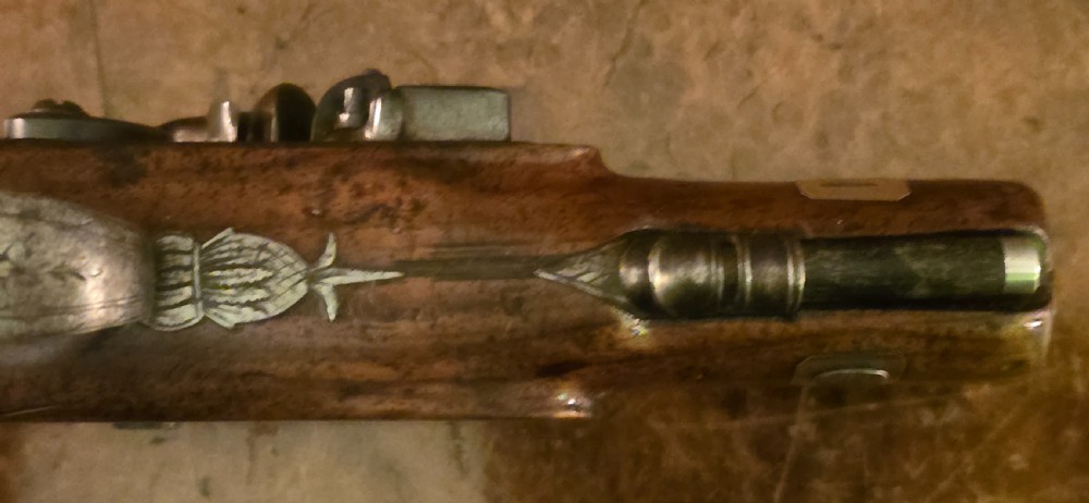 A Georgian British flintlock pocket pistol with a short octagonal barrel. Silver band & cartouche (not hallmarked), by 
Sutherland of London.  View XXIV