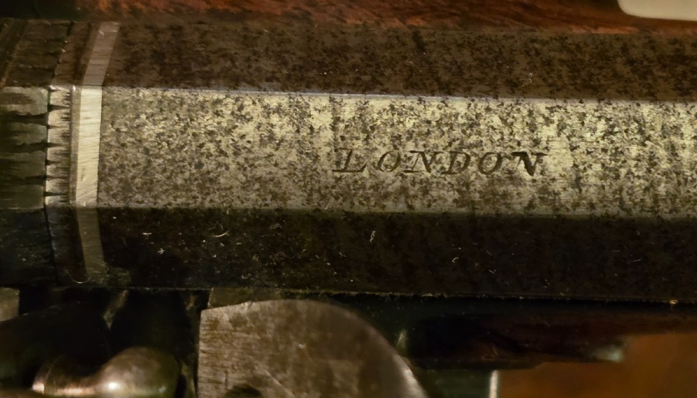 A Georgian British flintlock pocket pistol with a short octagonal barrel. Silver band & cartouche (not hallmarked), by 
Sutherland of London.  View XXVII