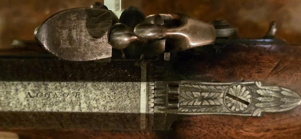 A Georgian British flintlock pocket pistol with a short octagonal barrel. Silver band & cartouche (not hallmarked), by 
Sutherland of London.  View XXVIII
