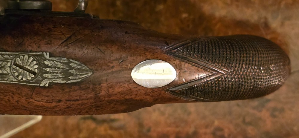 A Georgian British flintlock pocket pistol with a short octagonal barrel. Silver band & cartouche (not hallmarked), by 
Sutherland of London.  View XXIX