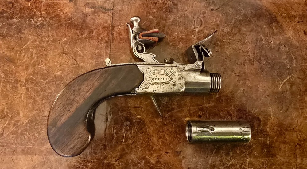 An 18th-century flintlock box-lock pocket pistol featuring a dark wooden grip, engraved steel receiver, and turn-off barrel. View XXVI