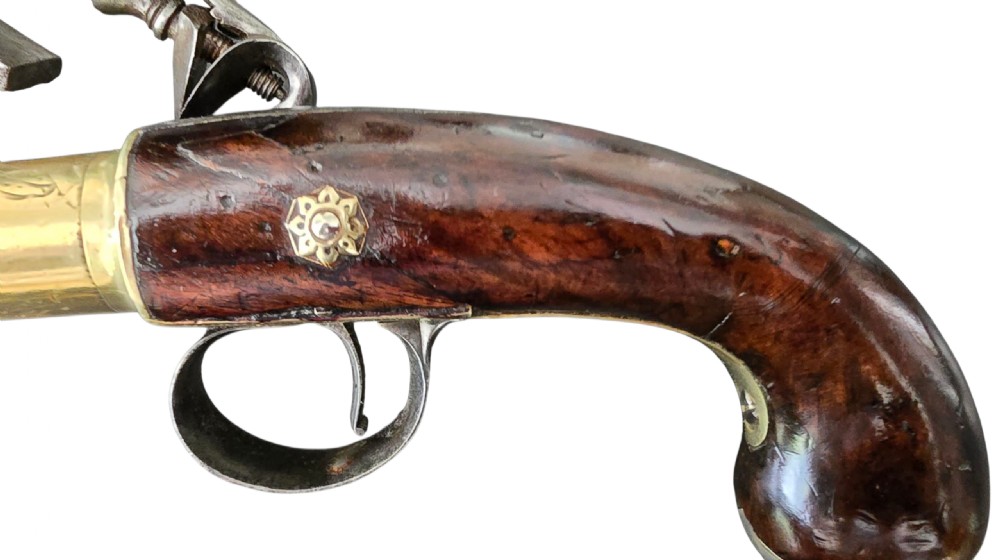 A pair of 18th-century English flintlock turn-off pistols featuring brass cannon barrels, steel lock mechanisms, and smooth walnut stocks. View X