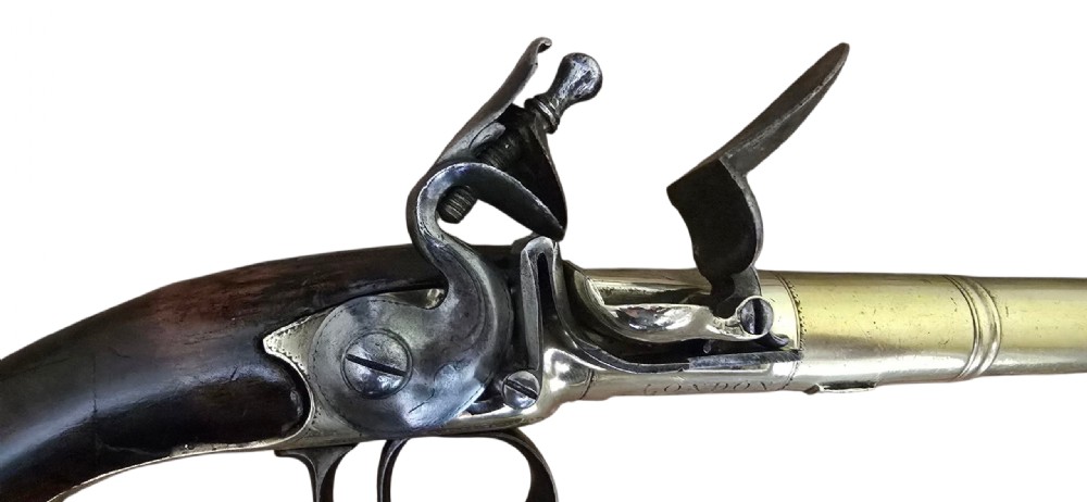 A pair of 18th-century English flintlock turn-off pistols featuring brass cannon barrels, steel lock mechanisms, and smooth walnut stocks. View XXX