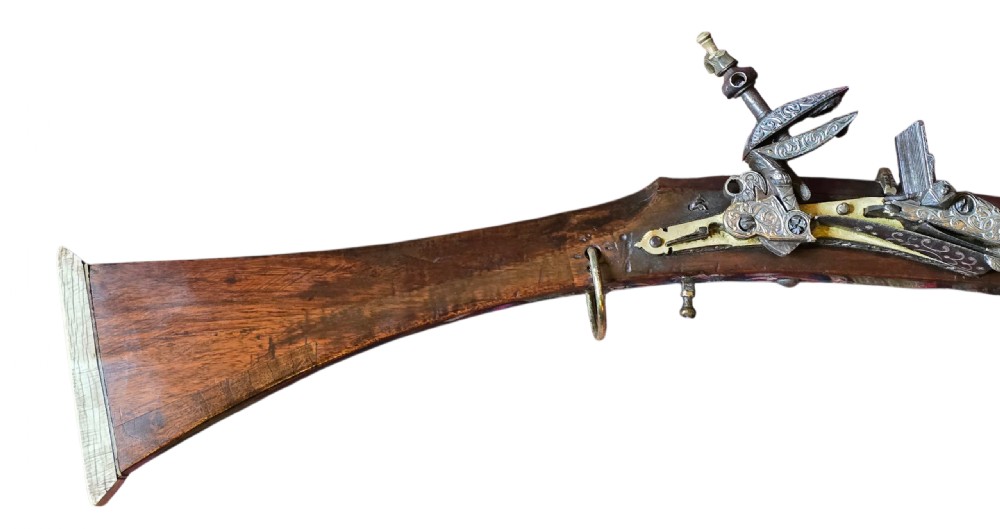 An 18th century Ottoman Algerian toe-lock long gun featuring a slender wooden stock decorated with brass bands and bone inlays. View VI