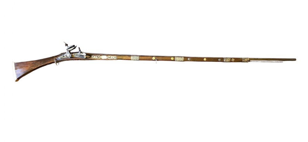 An 18th century Ottoman Algerian toe-lock long gun featuring a slender wooden stock decorated with brass bands and bone inlays. View XVII