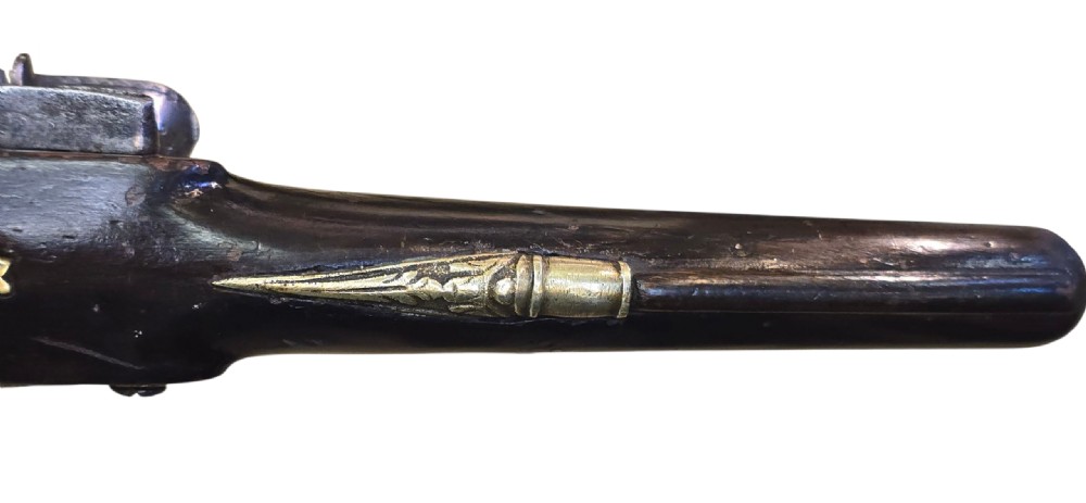 An antique Ottoman flintlock pistol featuring a dark carved wooden stock inlaid with silver accents and a steel barrel with gilt detailing. View VIII