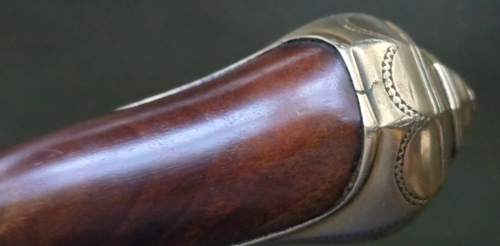 An 18th-century French flintlock holster pistol featuring a carved walnut stock, polished brass barrel, engraved brass lockplate, and steel mechanism. View XII